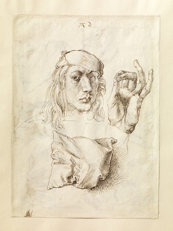 丢勒钢笔素描：同一张纸上画着画家的自画像、一只手和一个枕头，排线细密。